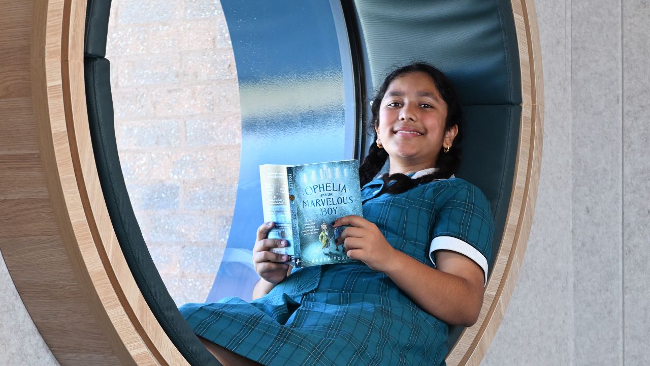 Student reading a book inside a school