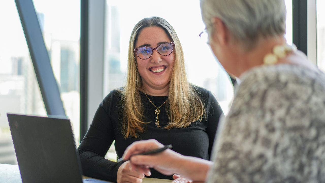Two women speaking in a corporate business environment